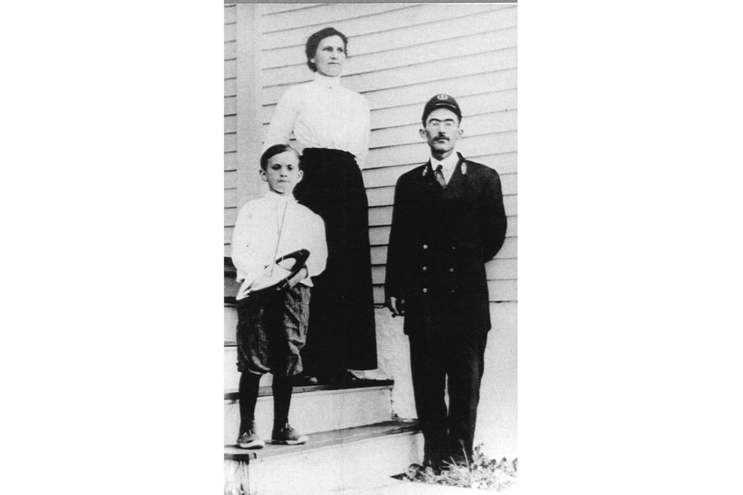 A man and woman standing on steps with a boy.