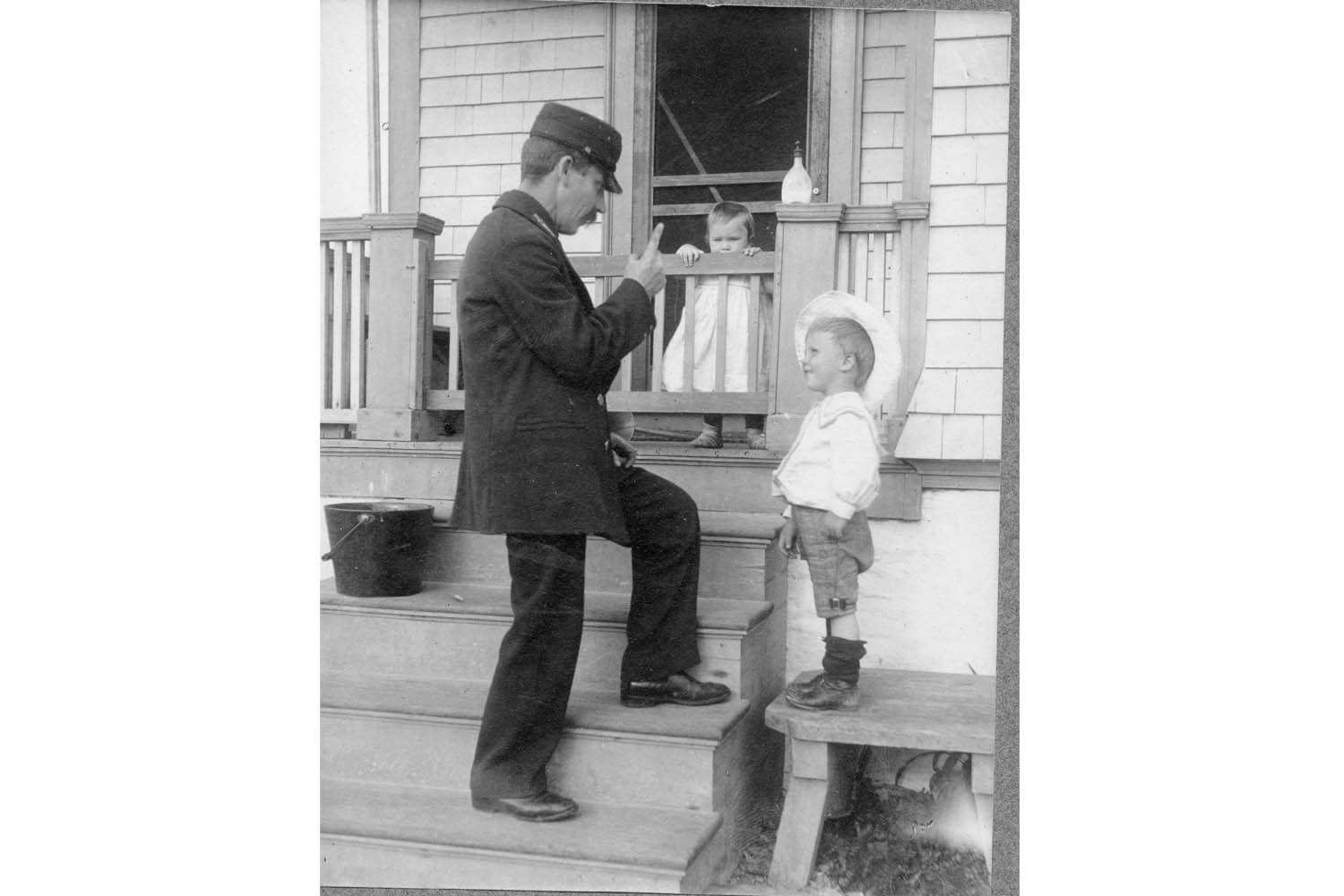 A man and boy on steps in front of house.