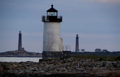 A group of lighthouses on the shore of a body of water.