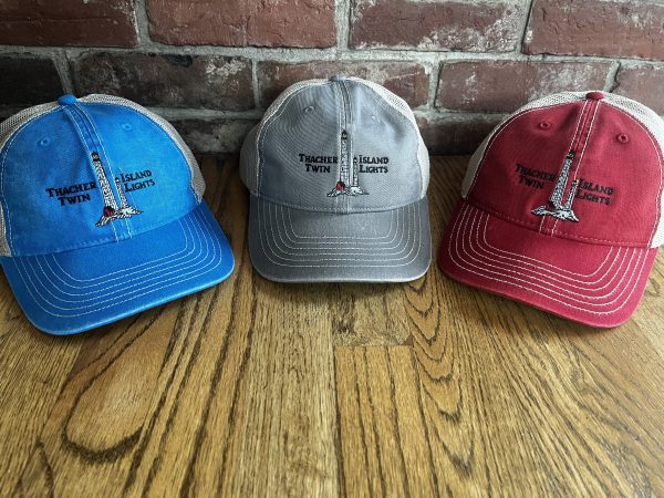 Three hats are sitting on a table in front of a brick wall.
